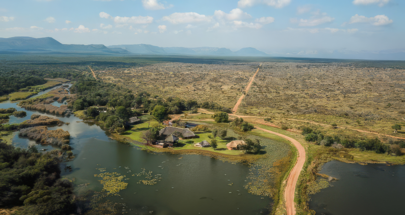 Aerial view of Aloe Africa hunting lodge beside river amid vast South African bushveld landscape